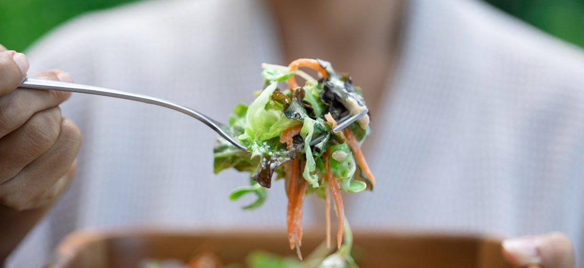 a person eating a salad with a fork
