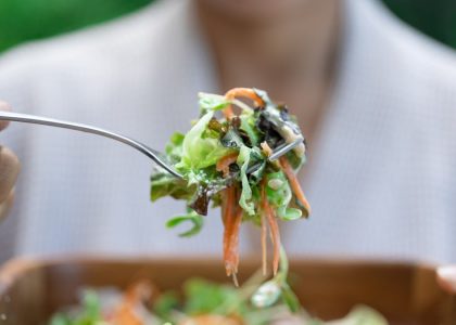 a person eating a salad with a fork