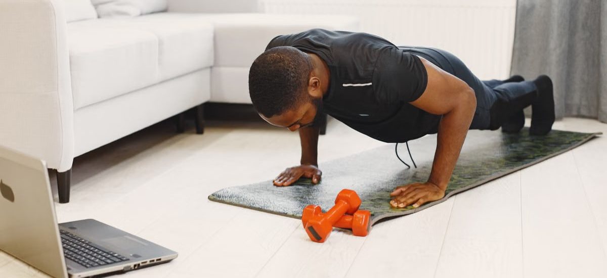 A man doing push-ups on a mat in a modern living room, focusing on home workouts.