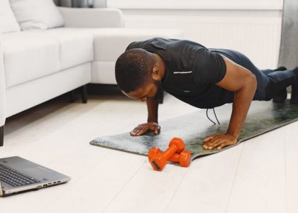 A man doing push-ups on a mat in a modern living room, focusing on home workouts.